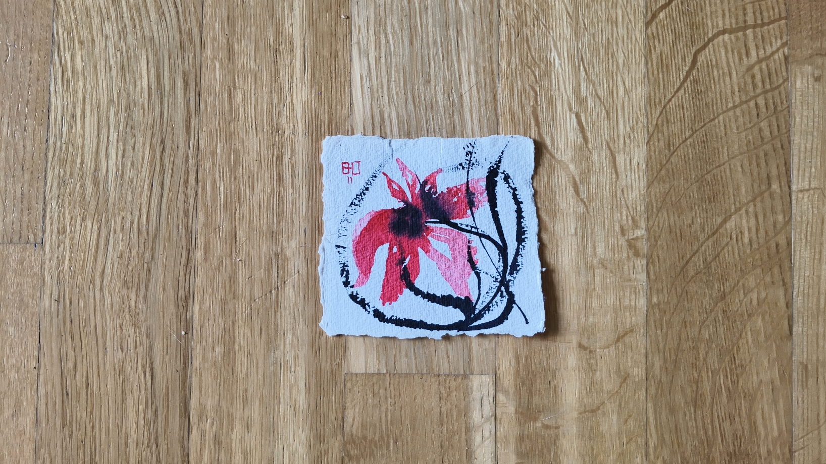 Schwarze und farbige Tuschespur auf handgeschöpftem Büttenpapier, inspiriert von einer aufblühenden Blüte – zeitgenössische Tuschekunst von Barbara Ossberger.