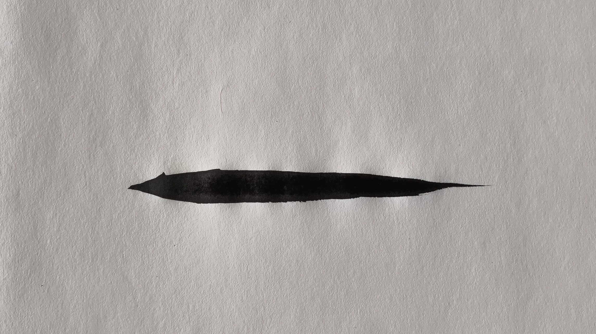 Tuschestrich auf weißem Papier, inspiriert von der Form eines Bambusblattes – zeitgenössische Tuschekunst von Barbara Ossberger.